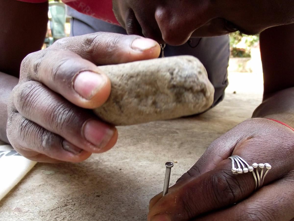 hammering a nail with a stone hammering a nail with a stone