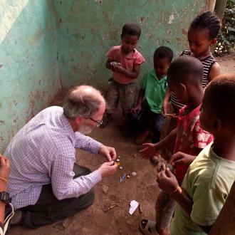 Ian Butler showing a child how to make a toy Ian Butler showing a child how to make a toy